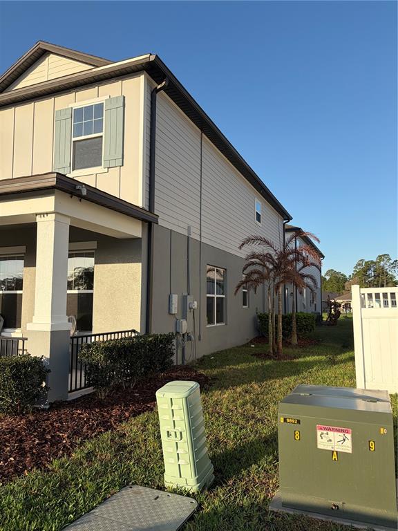 Two modern two-story houses with front porches stand side-by-side along a paved street — 2910 MELETO BOULEVARD, NEW SMYRNA BEACH, FL