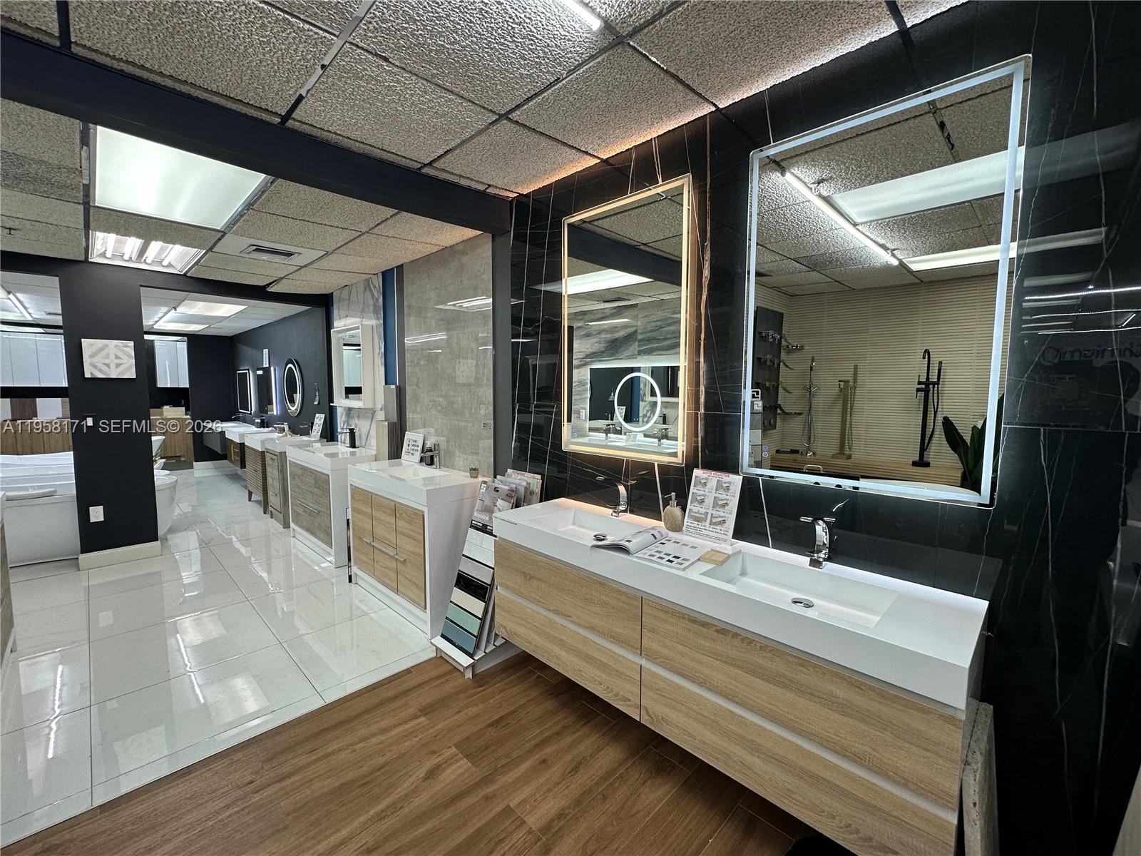 A showroom displays multiple modern bathroom vanities with wood cabinets and white countertops — DORAL, Doral FL 33166, DORAL, FL