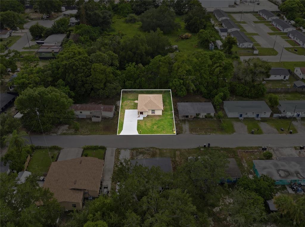 An aerial view shows a single-story house with a white driveway on a grassy lot — 728 HENRY ST, AUBURNDALE, FL