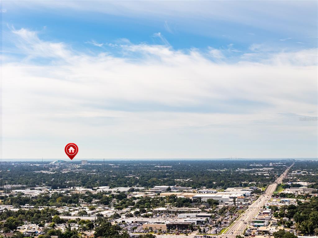 An aerial view shows a suburban landscape with a red house icon marking a location — 1703 12TH STREET S, ST PETERSBURG, FL