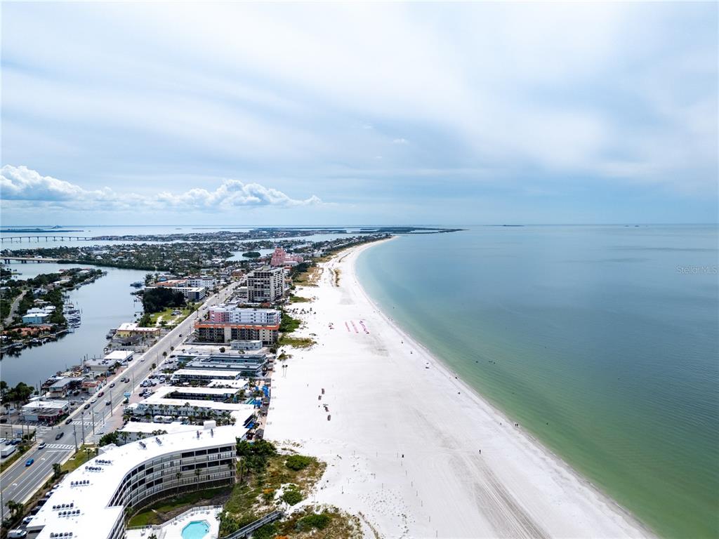 An aerial view shows a white sand beach bordering the ocean next to coastal buildings — 1703 12TH STREET S, ST PETERSBURG, FL