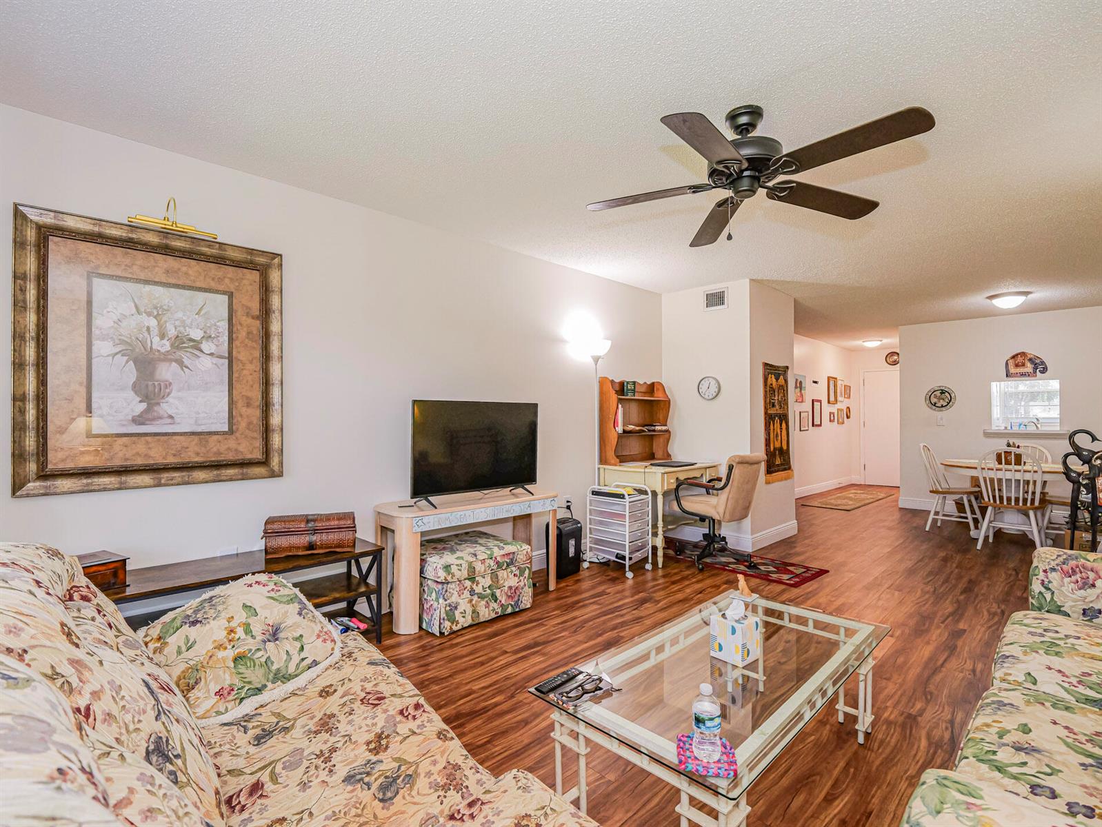 A living room with floral sofas, a glass coffee table, and wood-look flooring — 2800 Indian River Boulevard # 4r, Vero Beach FL 32960, VERO BEACH, FL