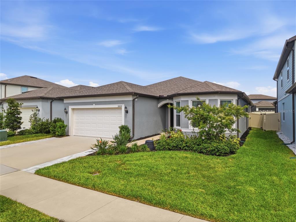 A single-story gray house with a two-car garage and a front lawn — 3834 MAPLE BAY LANE, LAND O LAKES, FL