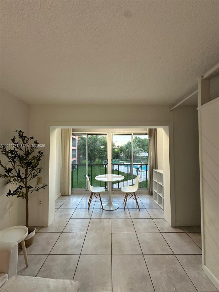 A dining area with tile floors features a small round table and two white chairs — 9405 W Flagler St # D204, Miami FL 33174, MIAMI, FL