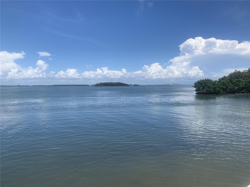 A swimming pool and hot tub are situated on a brick patio before apartment buildings — 1515 PINELLAS BAYWAY S UNIT 34, ST PETERSBURG, FL