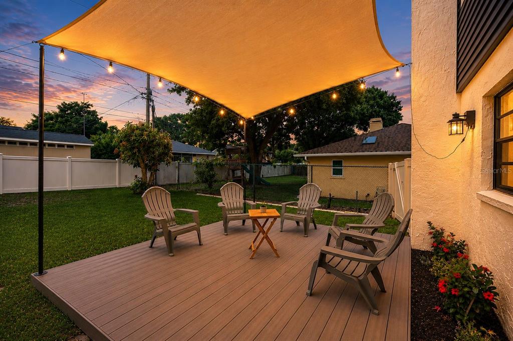 A two-story house with blue siding, a metal roof, and a front-facing garage at dusk — 3829 ERIC COURT, LAKELAND, FL