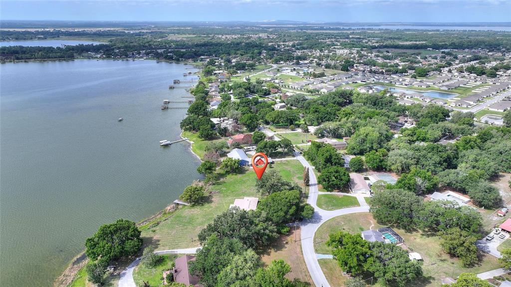 An aerial view shows a house with a red roof marker situated near a lake — LAKE AVENUE, WINTER HAVEN, FL