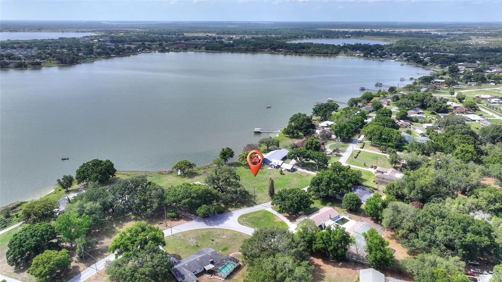 An aerial view shows a lakefront property with a red location pin on a lot — LAKE AVENUE, WINTER HAVEN, FL