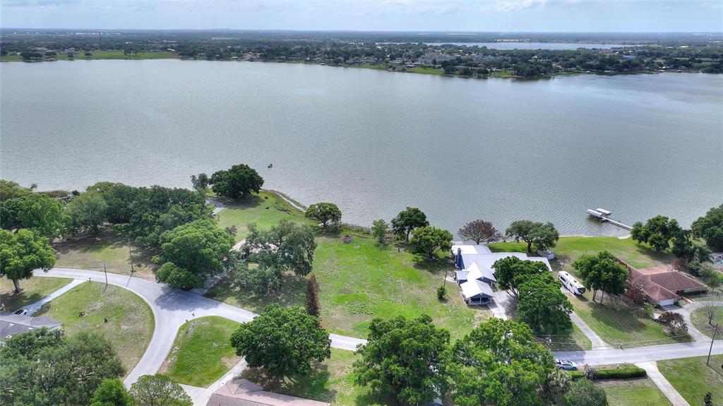 An aerial view shows a lakeside property with a house, trees, and a private dock — LAKE AVENUE, WINTER HAVEN, FL