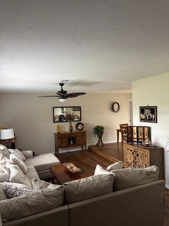 A living room features a sectional sofa, wooden flooring, a ceiling fan, and a sideboard — 17071 WATERS EDGE CIRCLE, NORTH FORT MYERS, FL