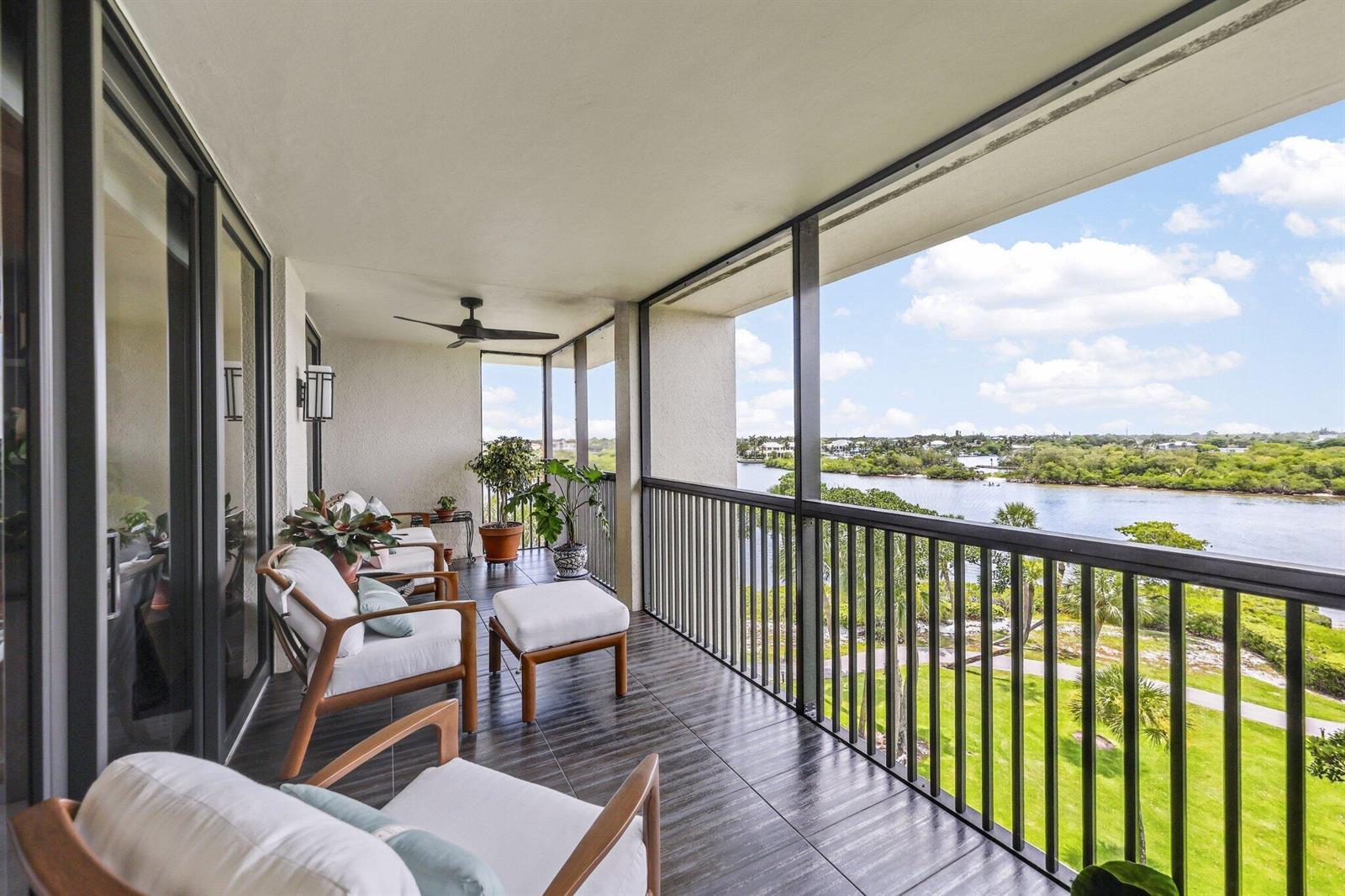A covered balcony features dark tiled flooring, patio furniture, and a view of the water — 1000 N Us Highway 1, Jupiter FL 33477, JUPITER, FL