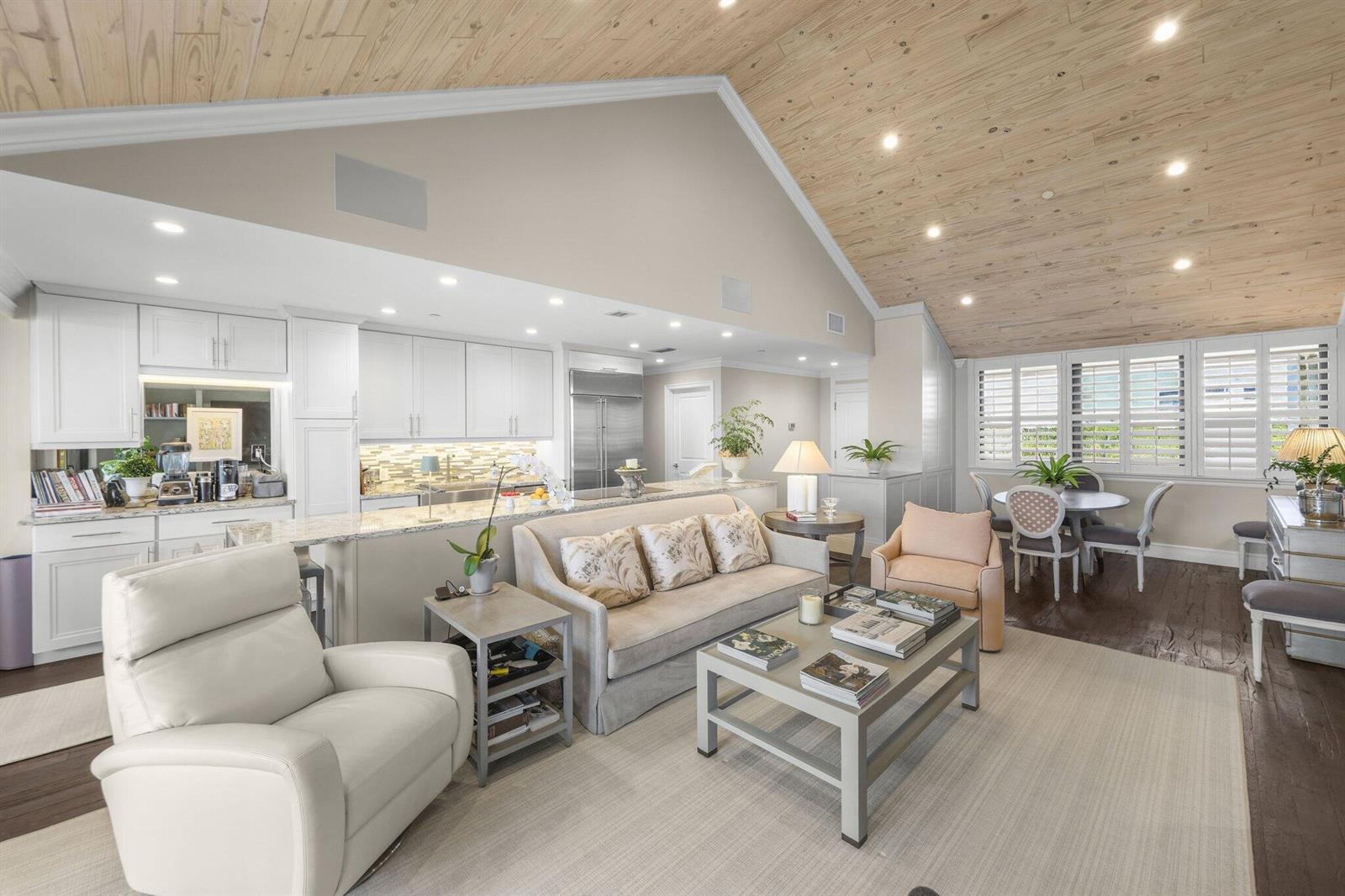 An open-concept living room and kitchen with vaulted wood ceilings and white cabinetry — 1000 N Us Highway 1, Jupiter FL 33477, JUPITER, FL