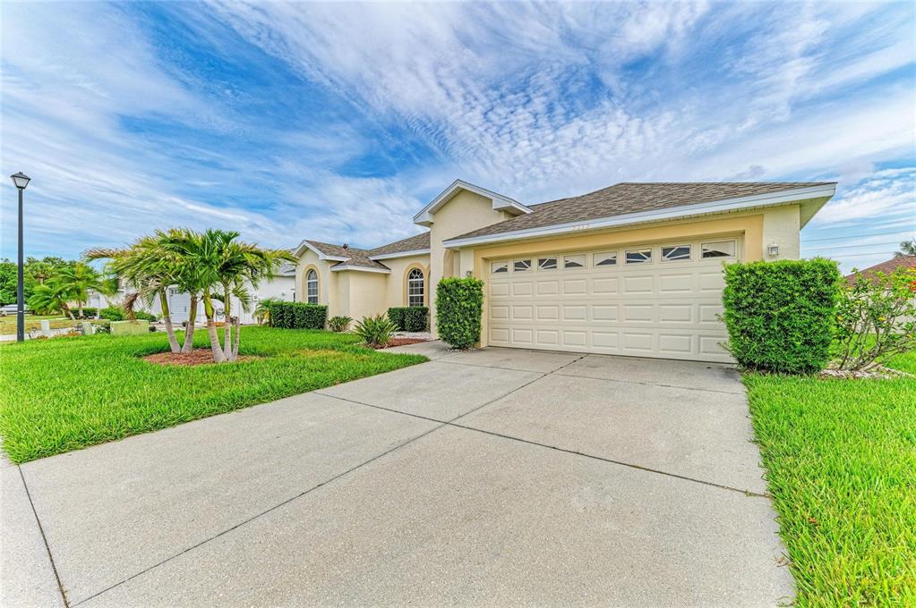 A single-story house with a beige stucco exterior, a two-car garage, and a concrete driveway — 3213 45TH AVENUE E, BRADENTON, FL
