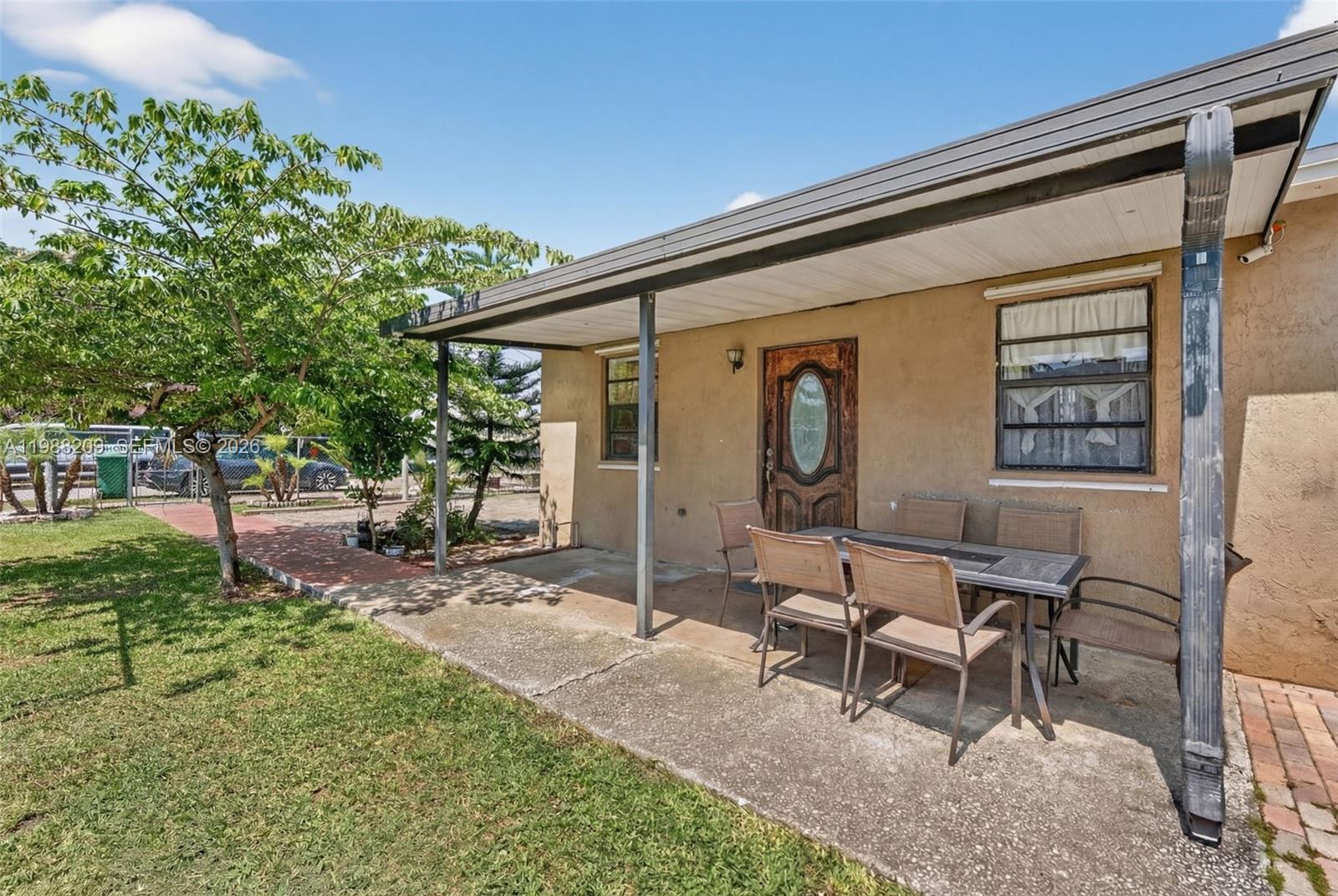 A covered concrete patio features a dining set in front of a house exterior — 26672 SW 137th Ct, Miami FL 33032, MIAMI, FL