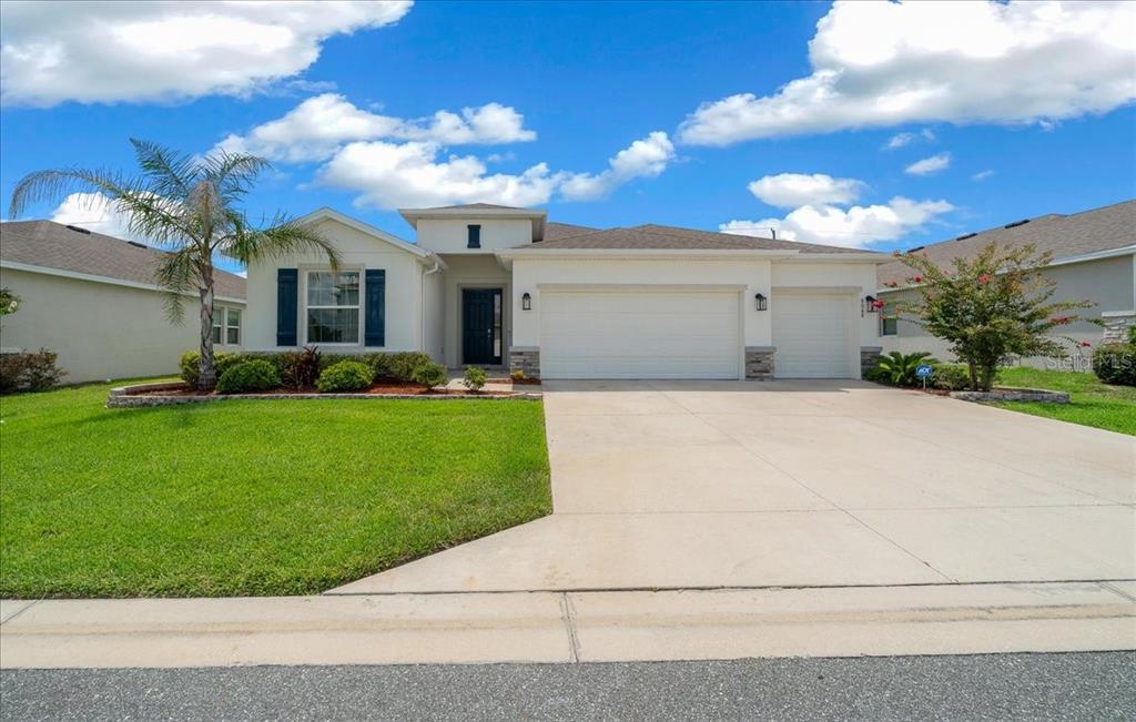 A single-story suburban house with a white exterior, a two-car garage, and a palm tree — 8068 SW 59TH TERRACE, OCALA, FL