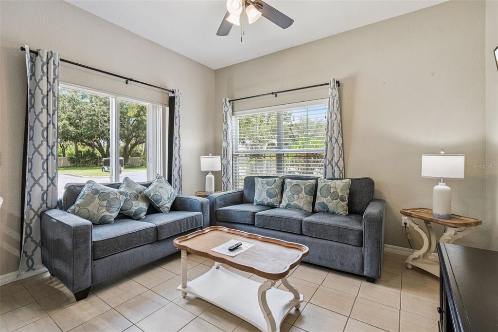 A living room features two gray sofas, a coffee table, and tile flooring — 2611 GALA ROAD N UNIT 108, KISSIMMEE, FL
