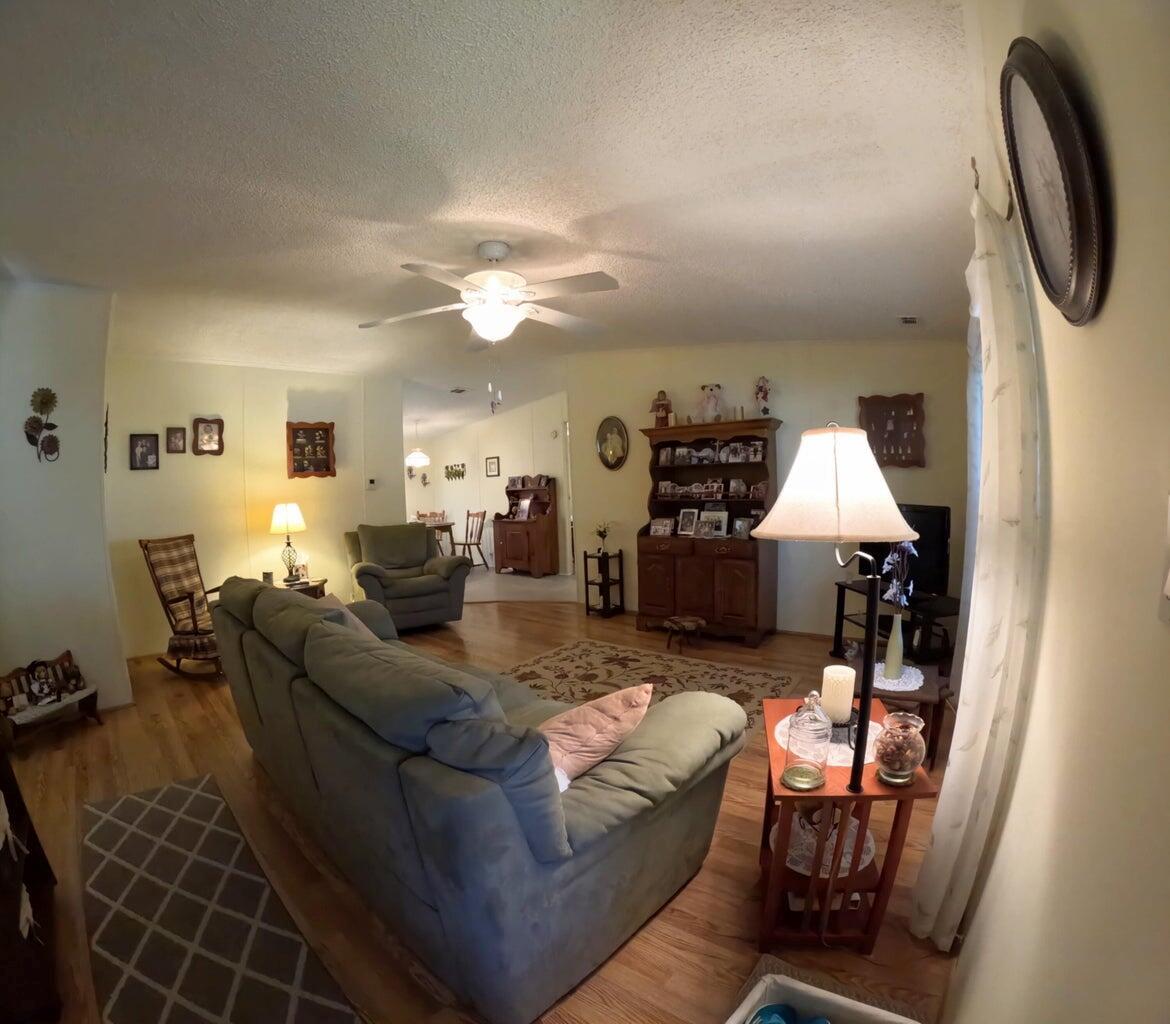 A living room with hardwood floors, a sofa, a hutch, and a ceiling fan — 6280 Cypress Lane, Lantana FL 33462, LANTANA, FL