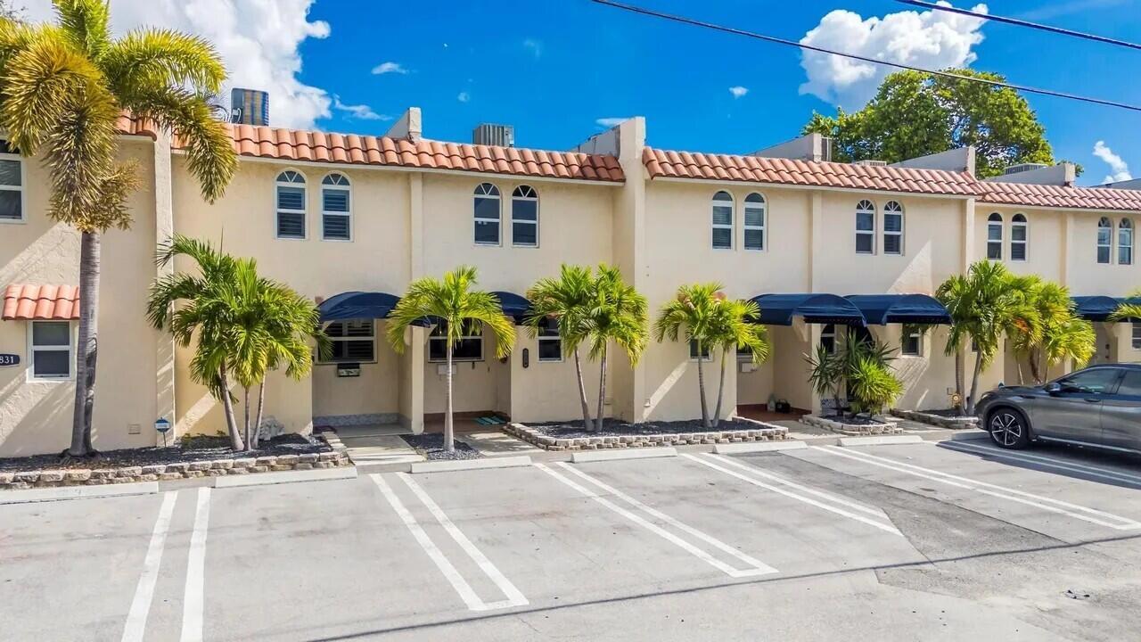 A row of two-story townhouses with beige stucco walls, arched windows, and a tiled roof — 1839 SE 4th Street, Pompano Beach FL 33060, POMPANO BEACH, FL
