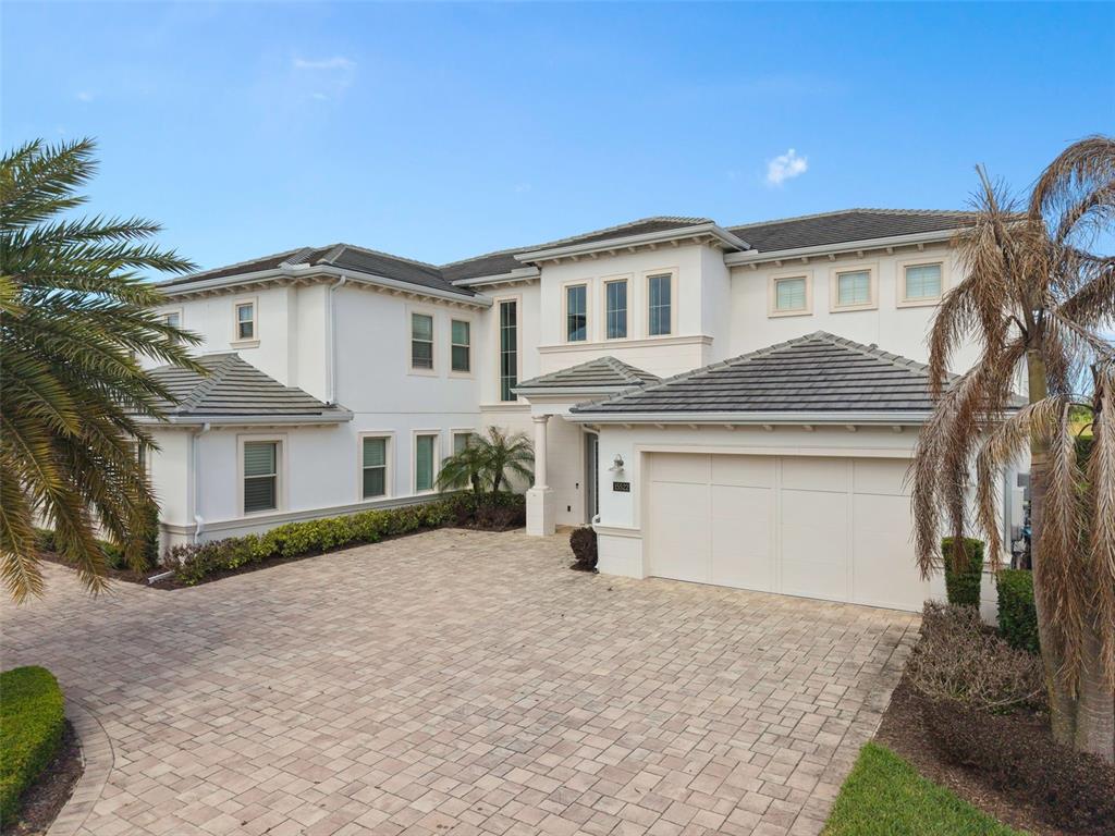 A two-story white stucco house with a tiled roof and a paved driveway — 15522 SHOREBIRD LANE, WINTER GARDEN, FL