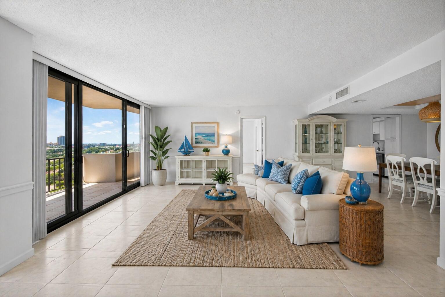 A bright living room features a beige sectional, wooden coffee table, and sliding glass balcony doors — 4200 N Ocean Drive # 804, Singer Island FL 33404, SINGER ISLAND, FL