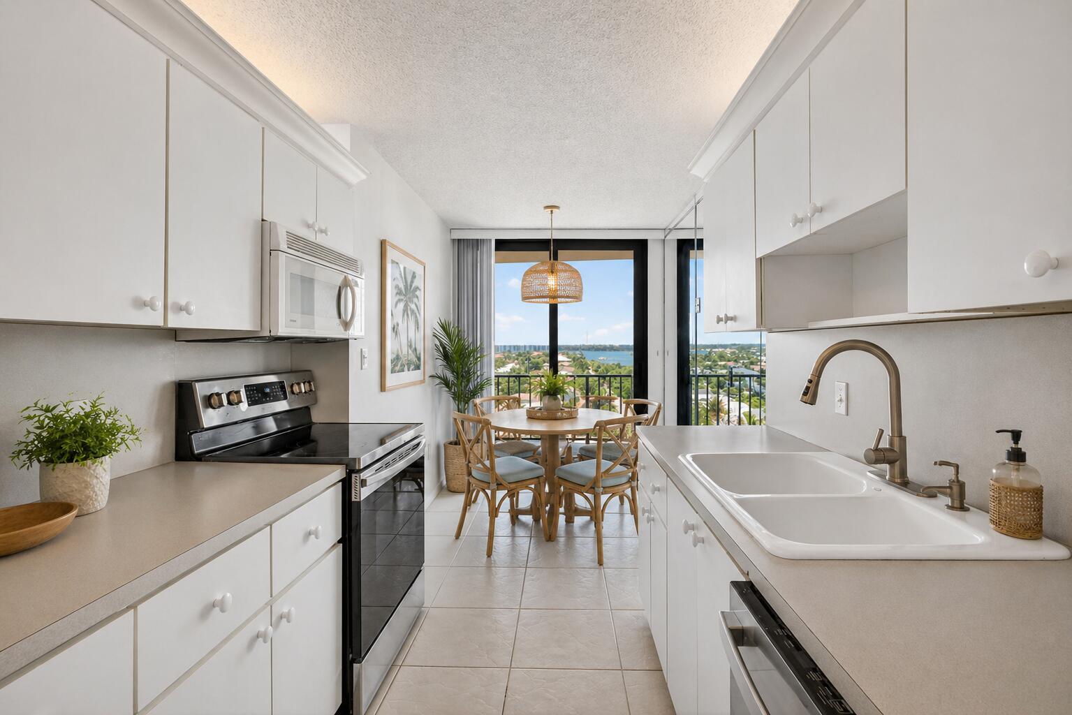 A galley kitchen with white cabinets and a dining area overlooking a coastal view — 4200 N Ocean Drive # 804, Singer Island FL 33404, SINGER ISLAND, FL