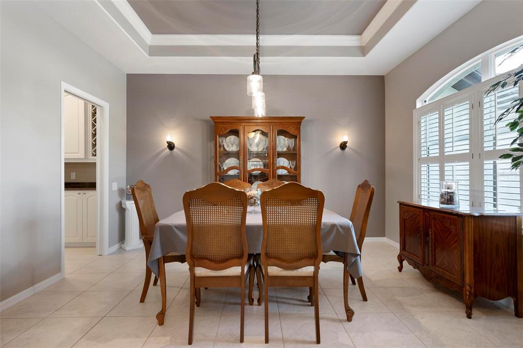 A living room features tile flooring, a leather sofa and armchair, and a ceiling fan — 7572 PALMER GLEN CIRCLE, SARASOTA, FL