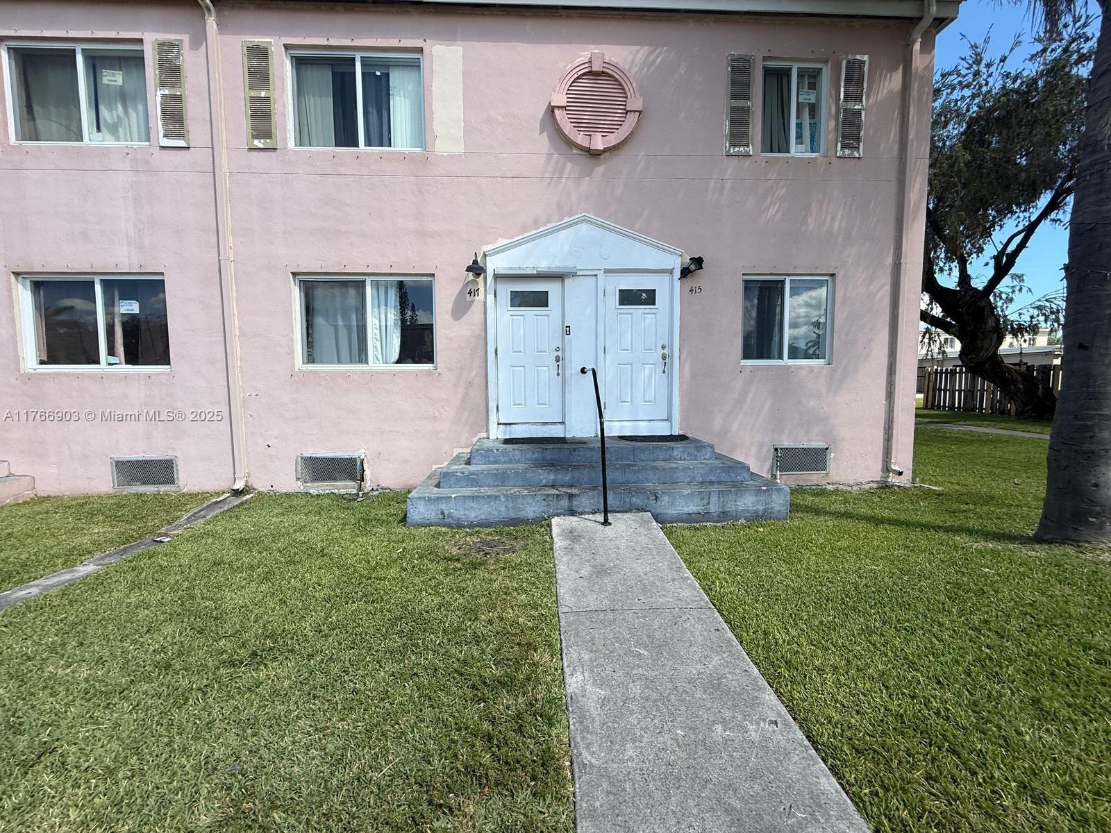 A two-story pink apartment building features a central entrance with two white doors — 417 NW 84th St # 417, Miami FL 33150, MIAMI, FL