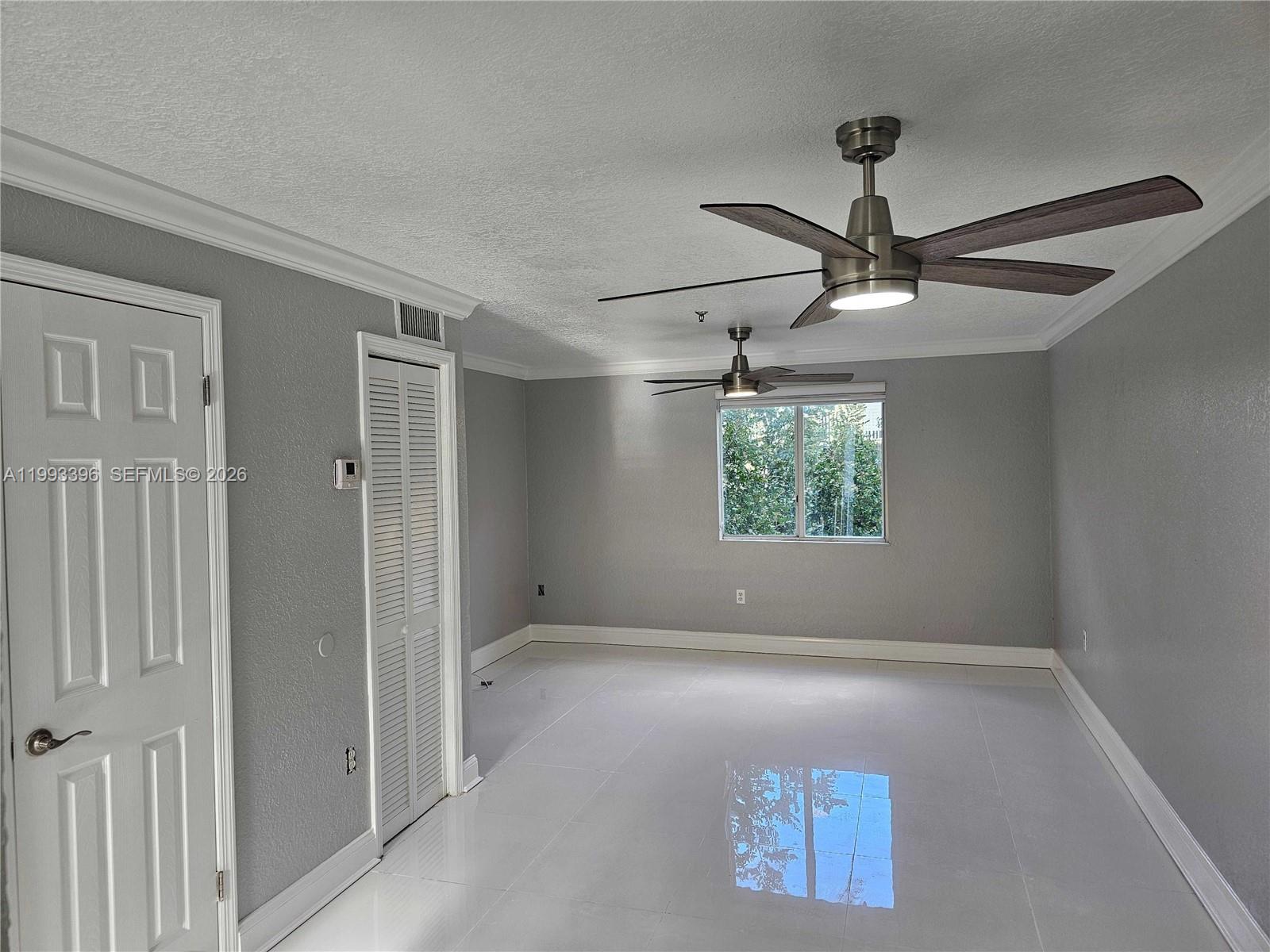 A room with gray walls, white tile flooring, and two ceiling fans — 8027 NW 8th St # 17, Miami FL 33126, MIAMI, FL