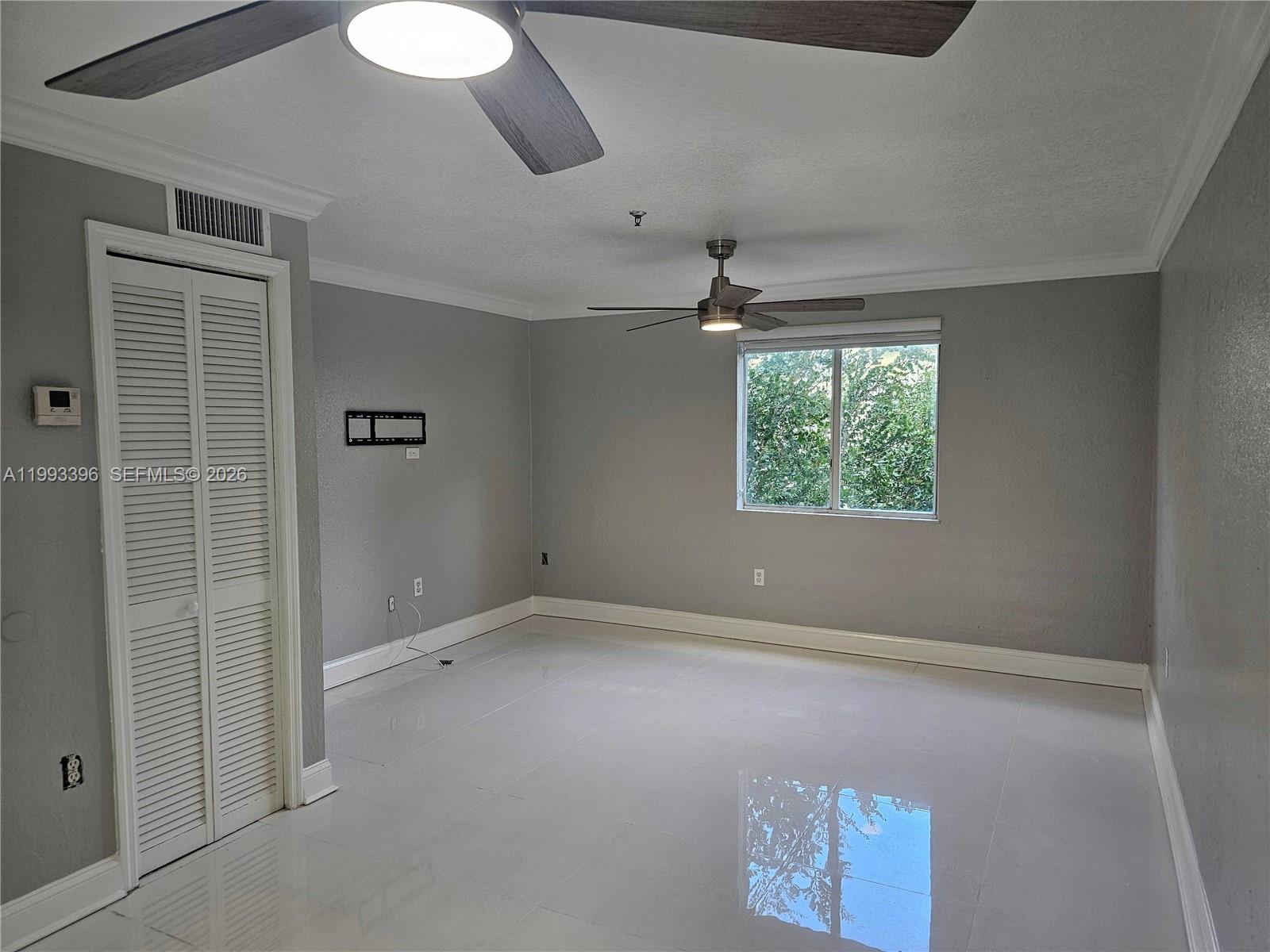 An empty room features gray walls, white tile flooring, a ceiling fan, and a closet — 8027 NW 8th St # 17, Miami FL 33126, MIAMI, FL