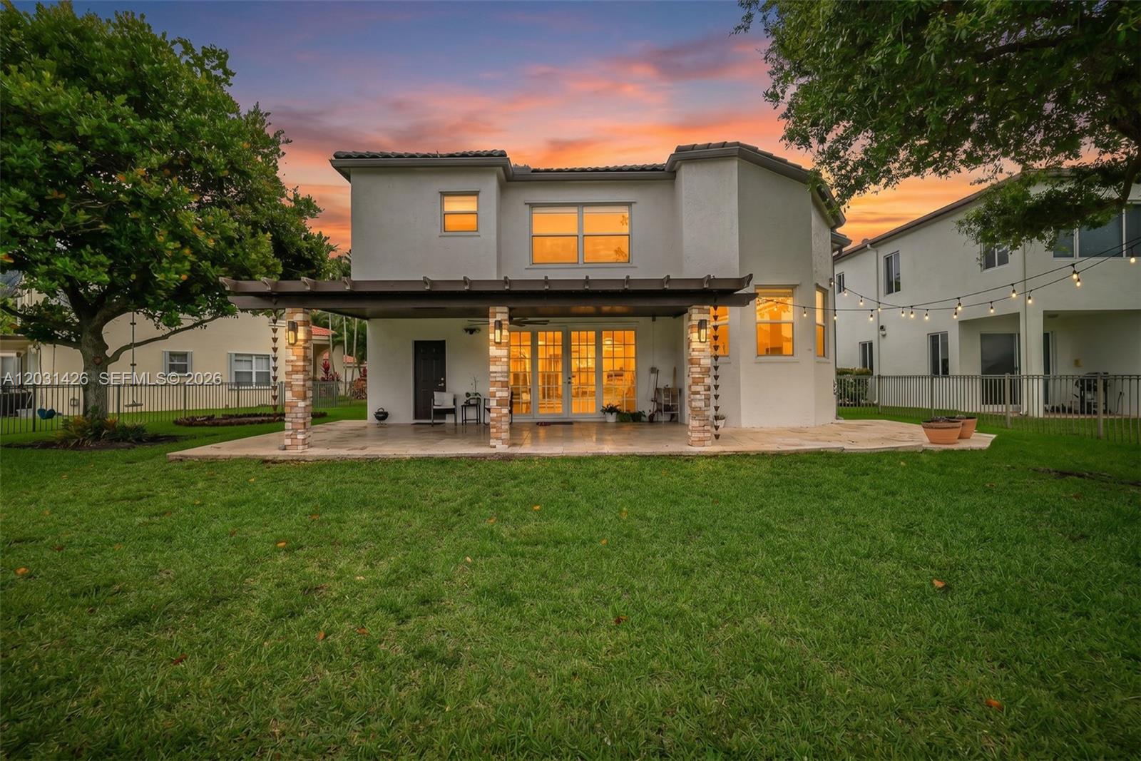 The rear exterior of a two-story house features a covered patio with stone-clad columns — 15815 SW 52nd Ct, Miramar FL 33027, MIRAMAR, FL
