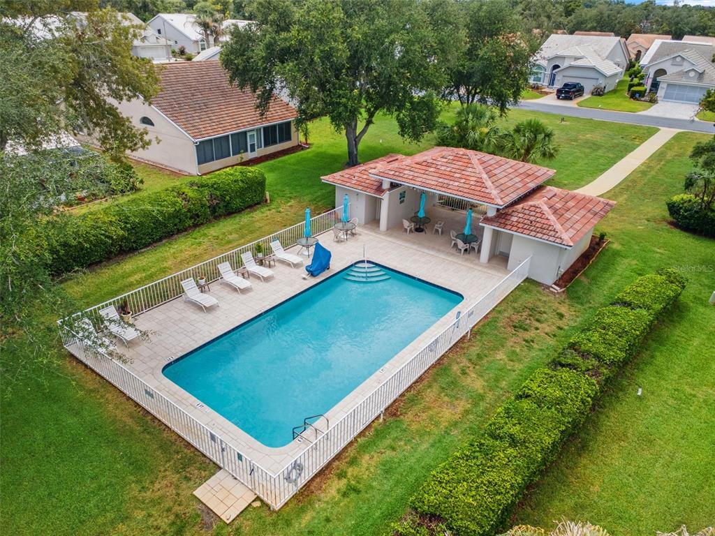 An aerial view shows a rectangular swimming pool with a covered patio and lounge chairs — 9419 NEW ORLEANS DRIVE, WEEKI WACHEE, FL