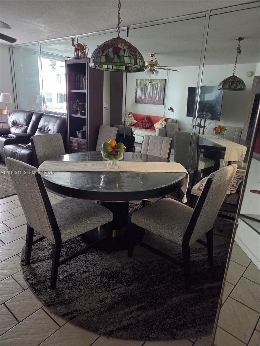 A dining area features a round table with four chairs, a pendant light, and mirrored walls — 1817 S Ocean Dr # 325, Hallandale Beach FL 33009, HALLANDALE BEACH, FL