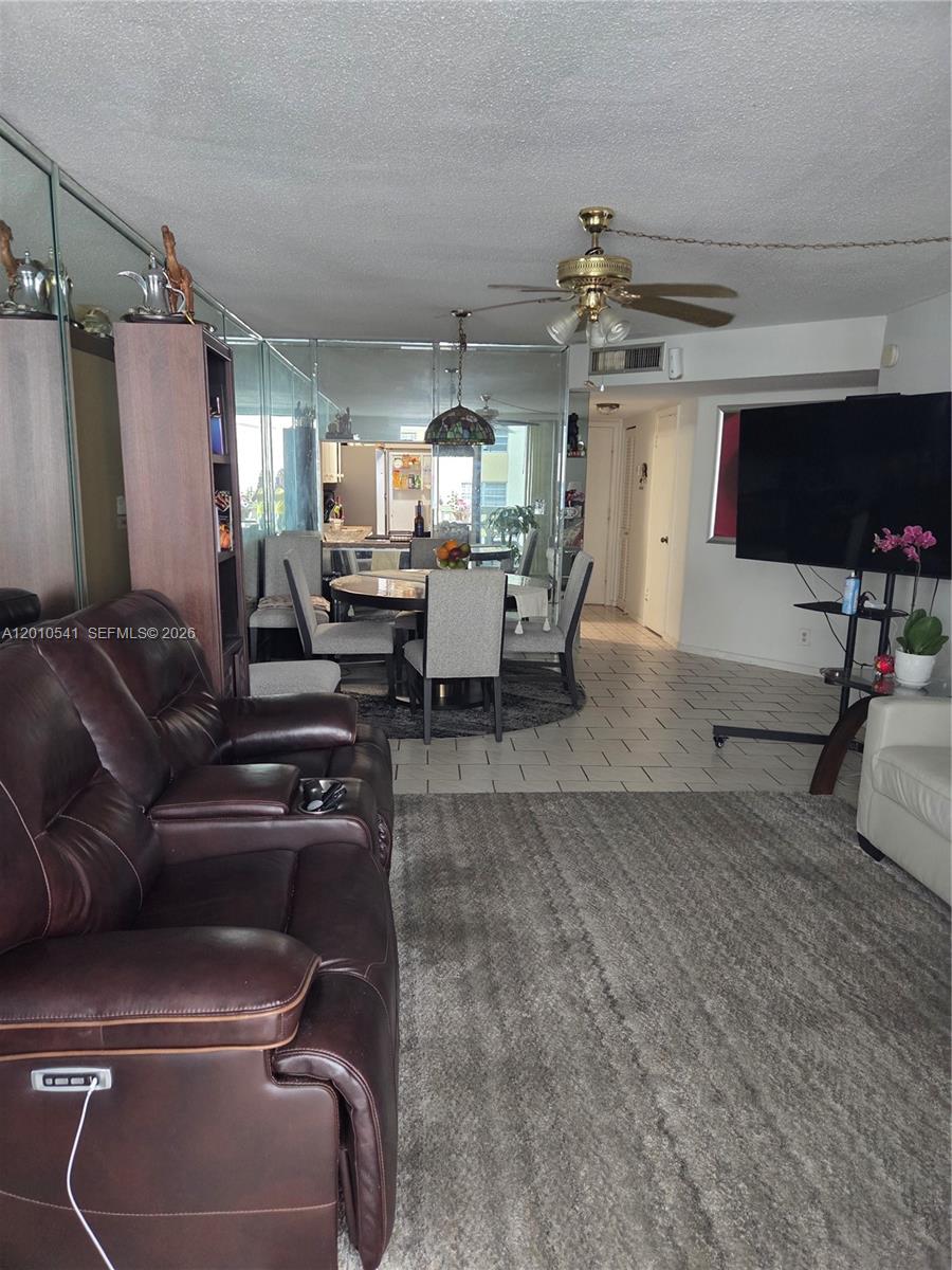 A living room with a brown leather recliner, dining area, and mirrored wall panels — 1817 S Ocean Dr # 325, Hallandale Beach FL 33009, HALLANDALE BEACH, FL
