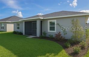 The exterior of a gray single-story house features a screened-in porch and a grassy lawn — 104 S COOPERS HAWK WAY, PALM COAST, FL
