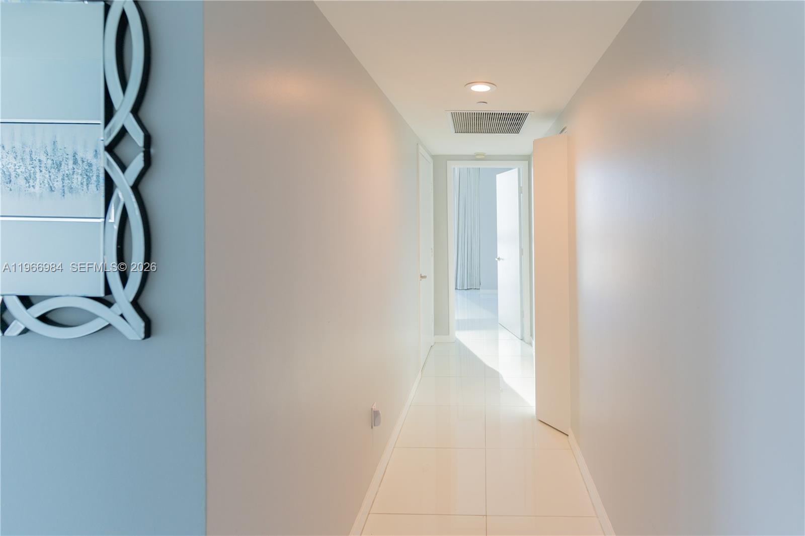 A bright hallway with white tile floors leads to an open doorway — 465 Brickell Ave # 4802, Miami FL 33131, MIAMI, FL