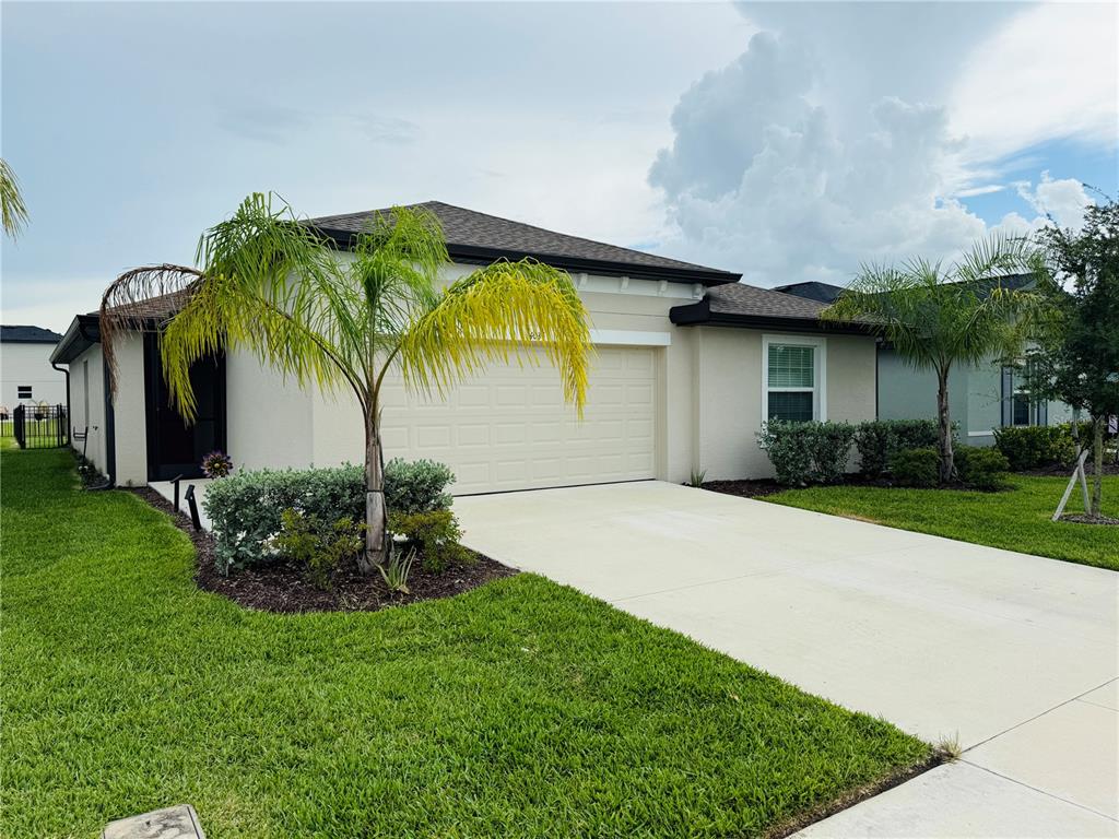 A single-story house with a beige exterior, a two-car garage, and palm trees in front — 4034 SAN CLEMENTE COURT, NORTH FORT MYERS, FL