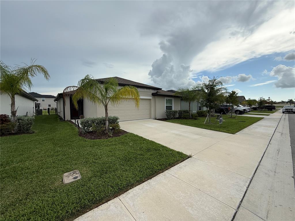 A single-story house with a beige exterior, a two-car garage, and palm trees in front — 4034 SAN CLEMENTE COURT, NORTH FORT MYERS, FL
