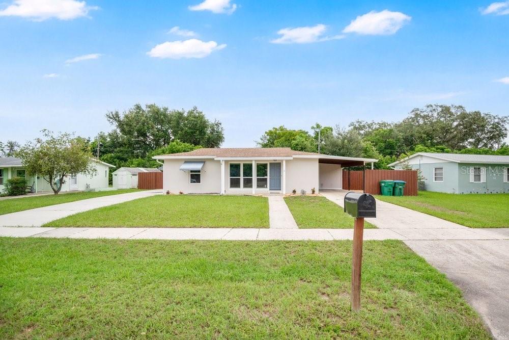 A single-story house with a light-colored exterior, a carport, and a front lawn — 1109 COBBLESTONE AVENUE, DELTONA, FL