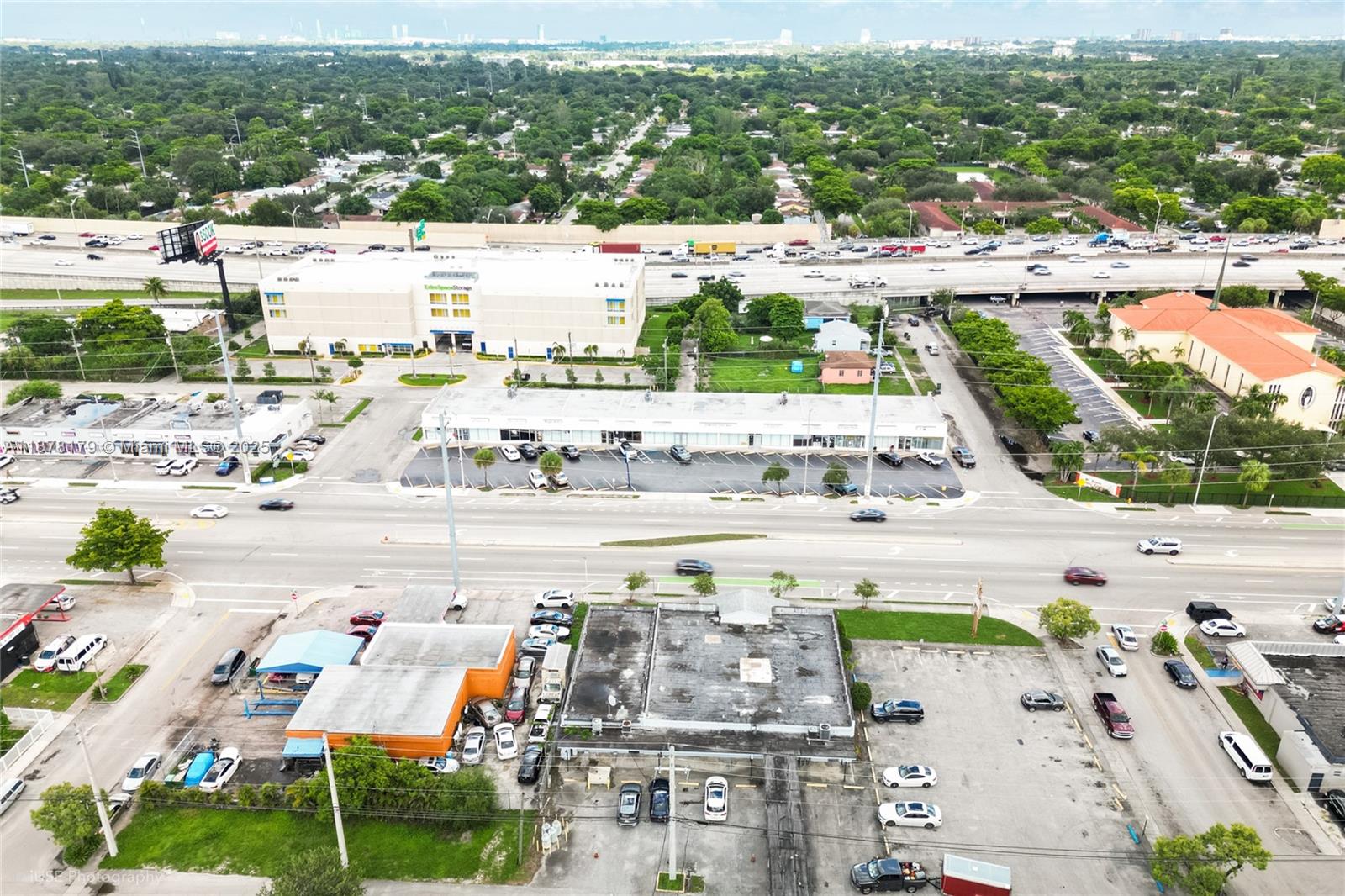 An aerial view shows a commercial building with a parking lot near a highway — 13242 NW 7th Ave, North Miami FL 33168, NORTH MIAMI, FL