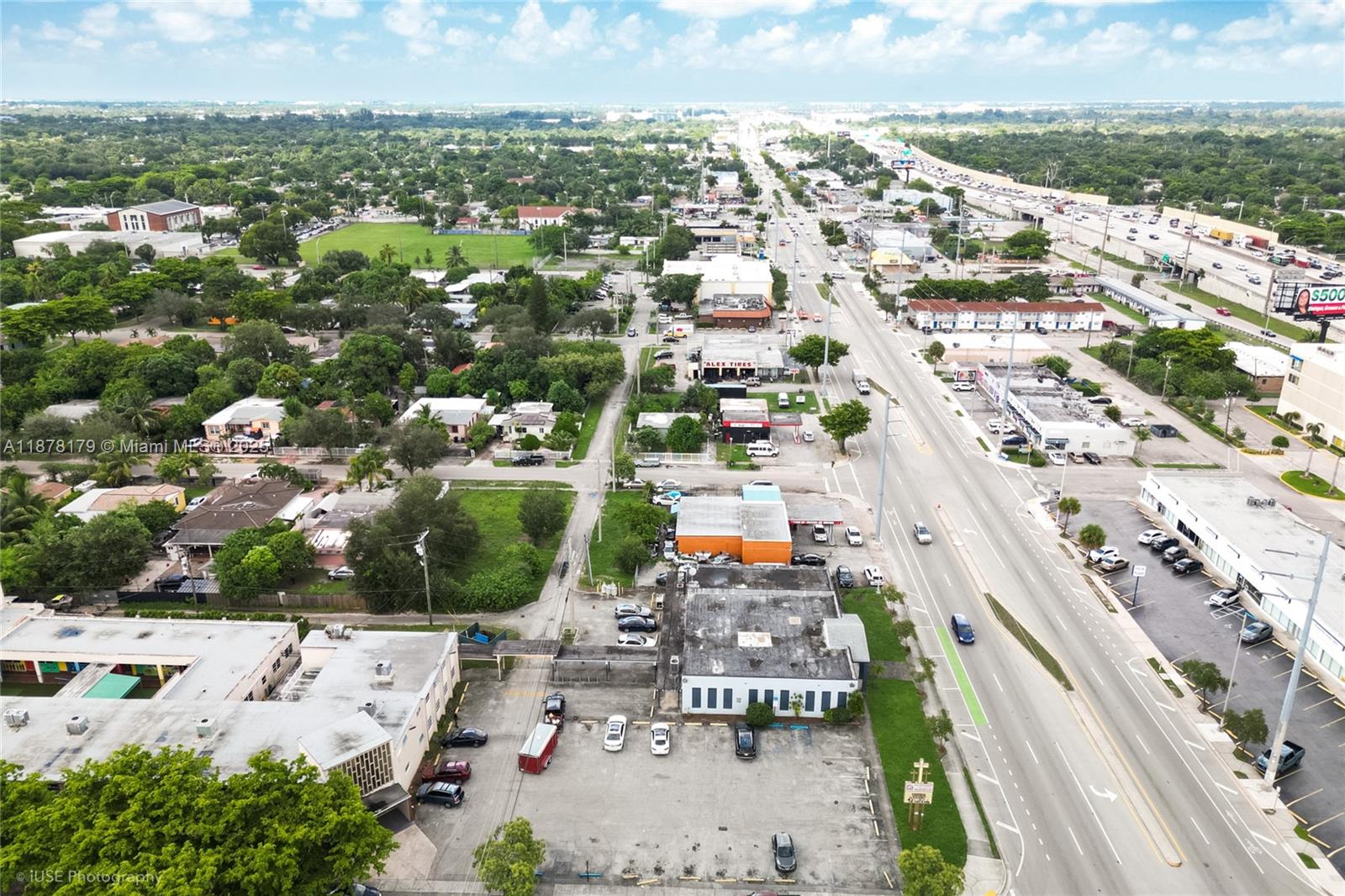 An aerial view shows a commercial building with a parking lot next to a road — 13242 NW 7th Ave, North Miami FL 33168, NORTH MIAMI, FL