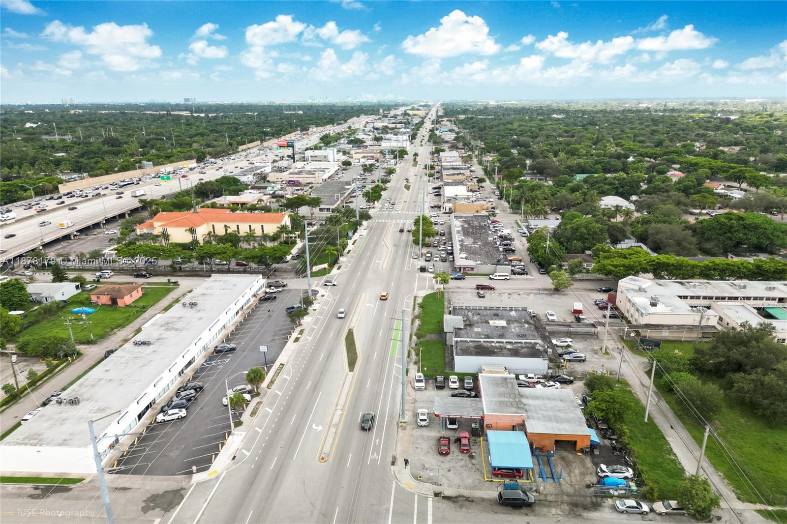 An aerial view shows a multi-lane road running through a commercial area with parking lots — 13242 NW 7th Ave, North Miami FL 33168, NORTH MIAMI, FL