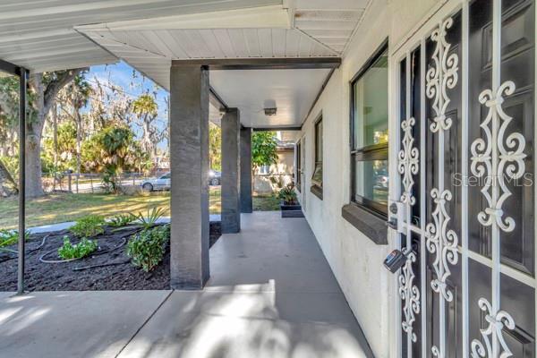 A covered concrete porch leads to a front door with a decorative white metal security gate — 635 MCCORMICK STREET, DAYTONA BEACH, FL