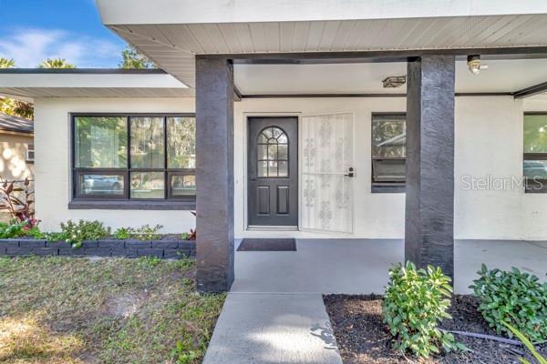 A covered front porch leads to a dark gray front door with a glass insert — 635 MCCORMICK STREET, DAYTONA BEACH, FL