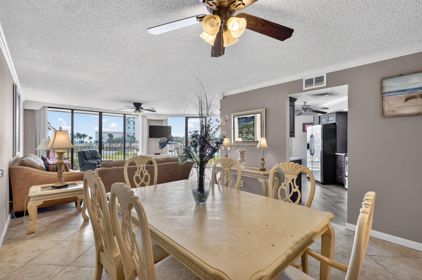 A dining area with a light-colored table and chairs opens into a living room with views — 9650 S Ocean Drive # 210, Jensen Beach FL 34957, JENSEN BEACH, FL