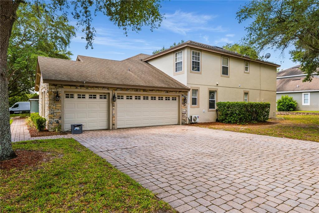 A two-story house with a stone-accented garage and a paved driveway — 2928 PARK MEADOW DRIVE, APOPKA, FL