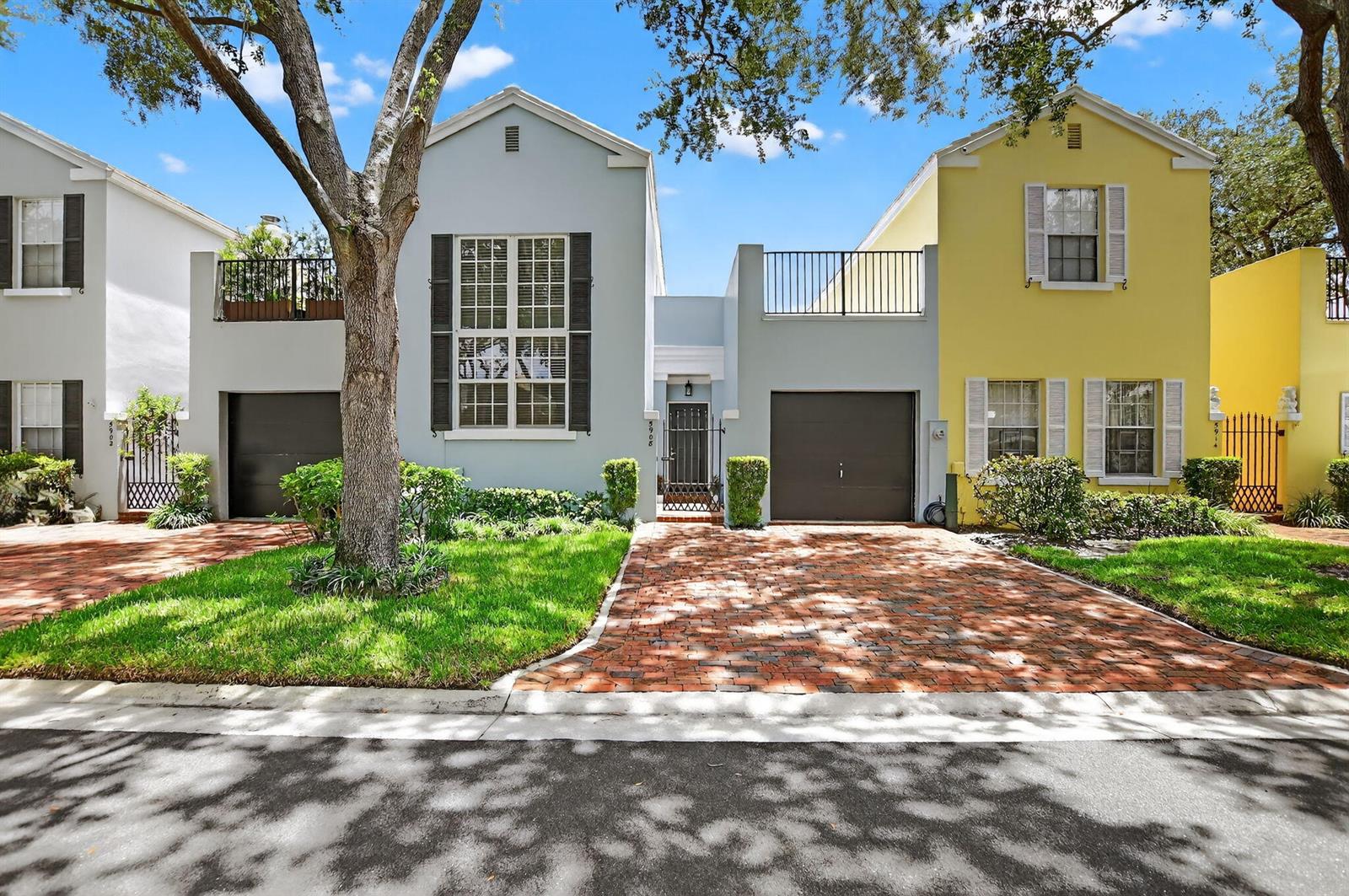 A light blue and a yellow two-story townhouse with brick driveways and attached garages — 5908 Catesby Street, Boca Raton FL 33433, BOCA RATON, FL