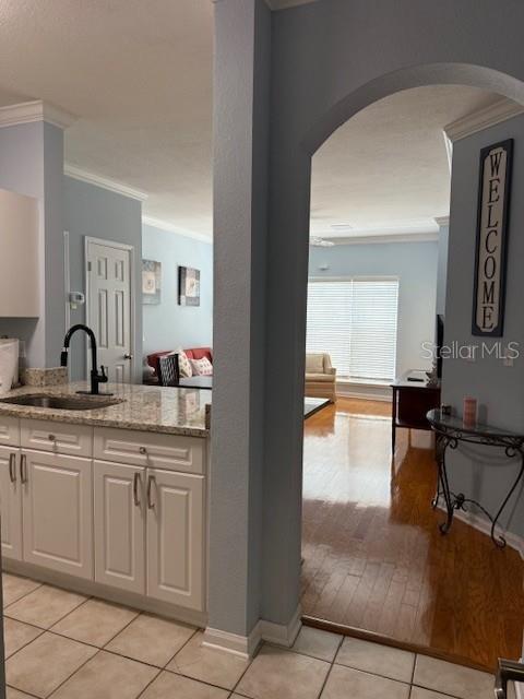 A kitchen with granite countertops and white cabinets opens into a living area with flooring — 1216 S MISSOURI AVENUE UNIT 227, CLEARWATER, FL