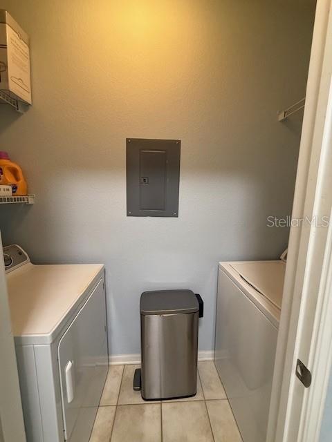 A laundry room features a washer, a dryer, a trash can, and a wall-mounted electrical panel — 1216 S MISSOURI AVENUE UNIT 227, CLEARWATER, FL