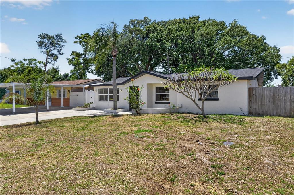 A single-story house with a carport, a palm tree, and a sparse front lawn — 3851 SATURN DRIVE, NEW PORT RICHEY, FL