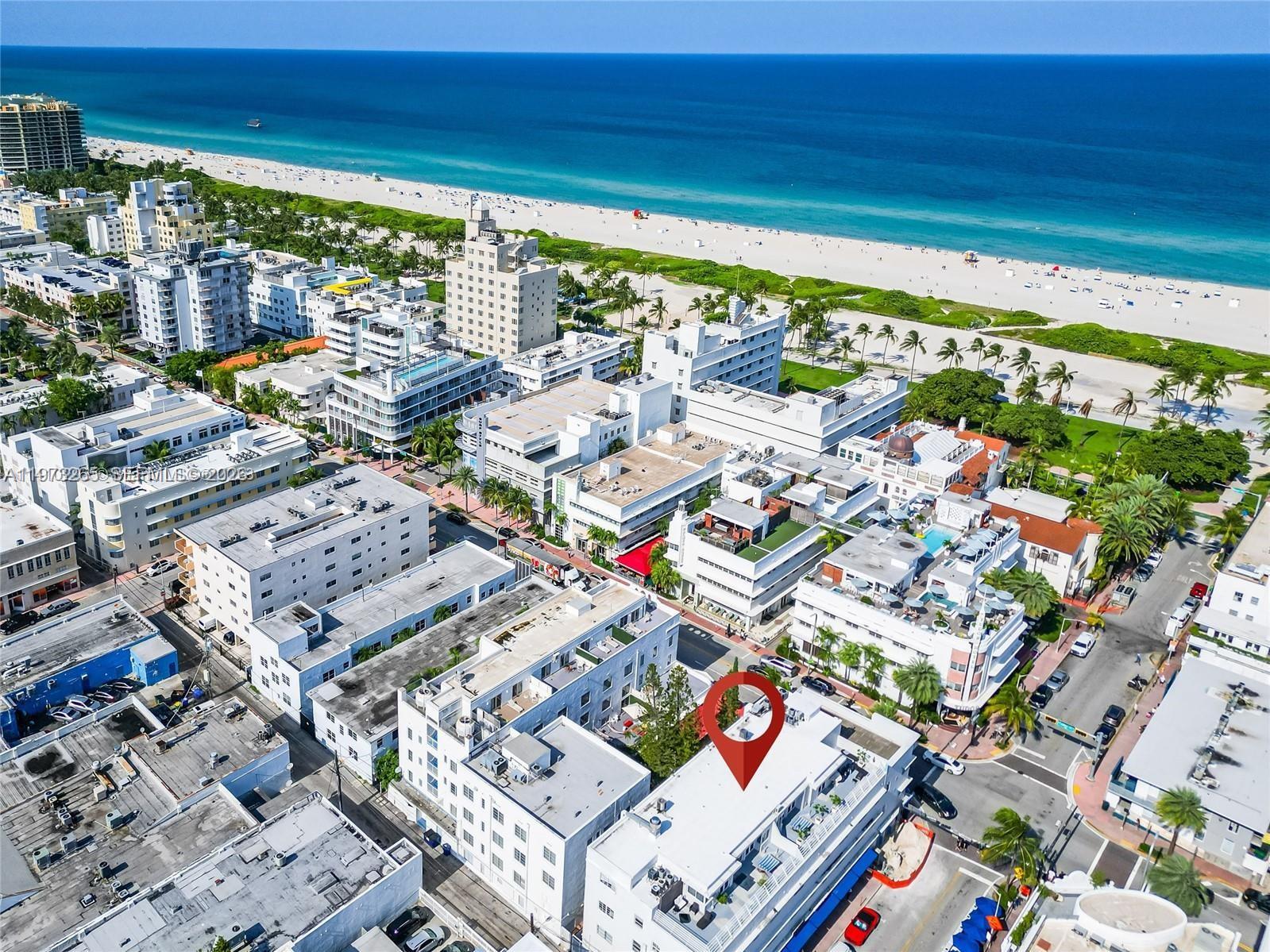An aerial view shows a white multi-story building marked with a red pin near the beach — 1100 Collins Ave # 303, Miami Beach FL 33139, MIAMI BEACH, FL